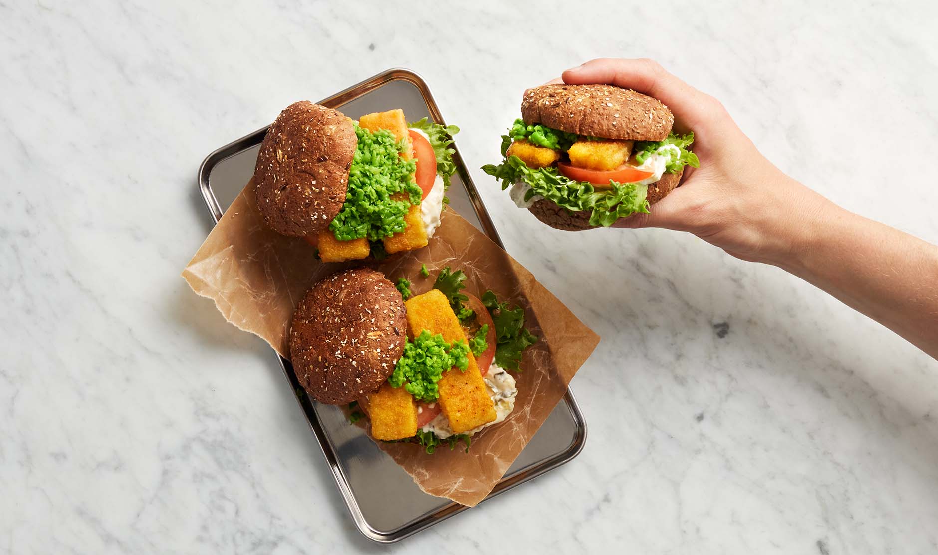 Fiskpinneburgere med ertemos og syltegurkmajones